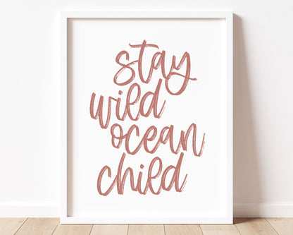 Neutral Tan Stay Wild Ocean Child Printable Wall Art featuring a textured brush style cursive lettered quote in a muted, dusty rose color.