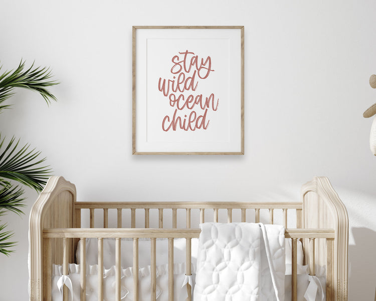 Dusky Rose Stay Wild Ocean Child Printable Wall Art featuring a textured brush style cursive lettered quote in a soft, dusty pink color. Perfect for Baby Girl Nautical Nursery Decor, Surf Nursery Wall Art, Beach Nursery Art, Nautical Kids Bedroom Decor or Children's Coastal Bathroom Wall Art.